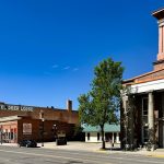 Looking down Main Street in Deer Lodge, MT with a clock tower building in the foreground