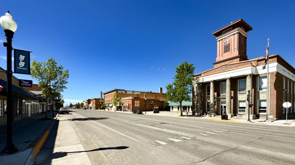Looking down Main Street in Deer Lodge, MT with a clock tower building in the foreground