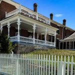 old building at a historic site, along with a white picket fence